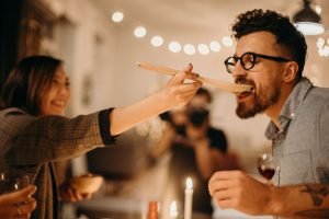  mulher dá comida na boca de homem em festa