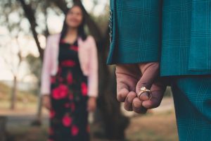 homem segura um anel de noivado em suas mãos para fazer o pedido de casamento