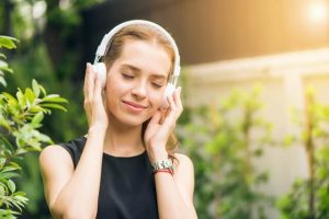 mulher escuta com rosto relaxado música com mensagem de positividade 