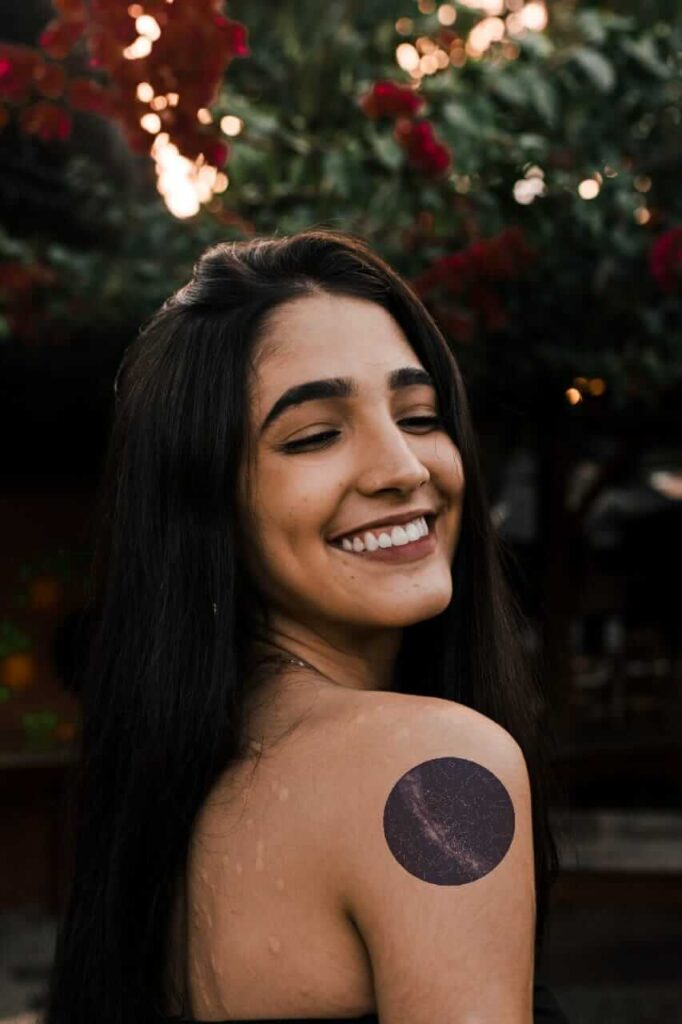 menina sorri com tatuagem de universo no ombro do mapa das estrelas